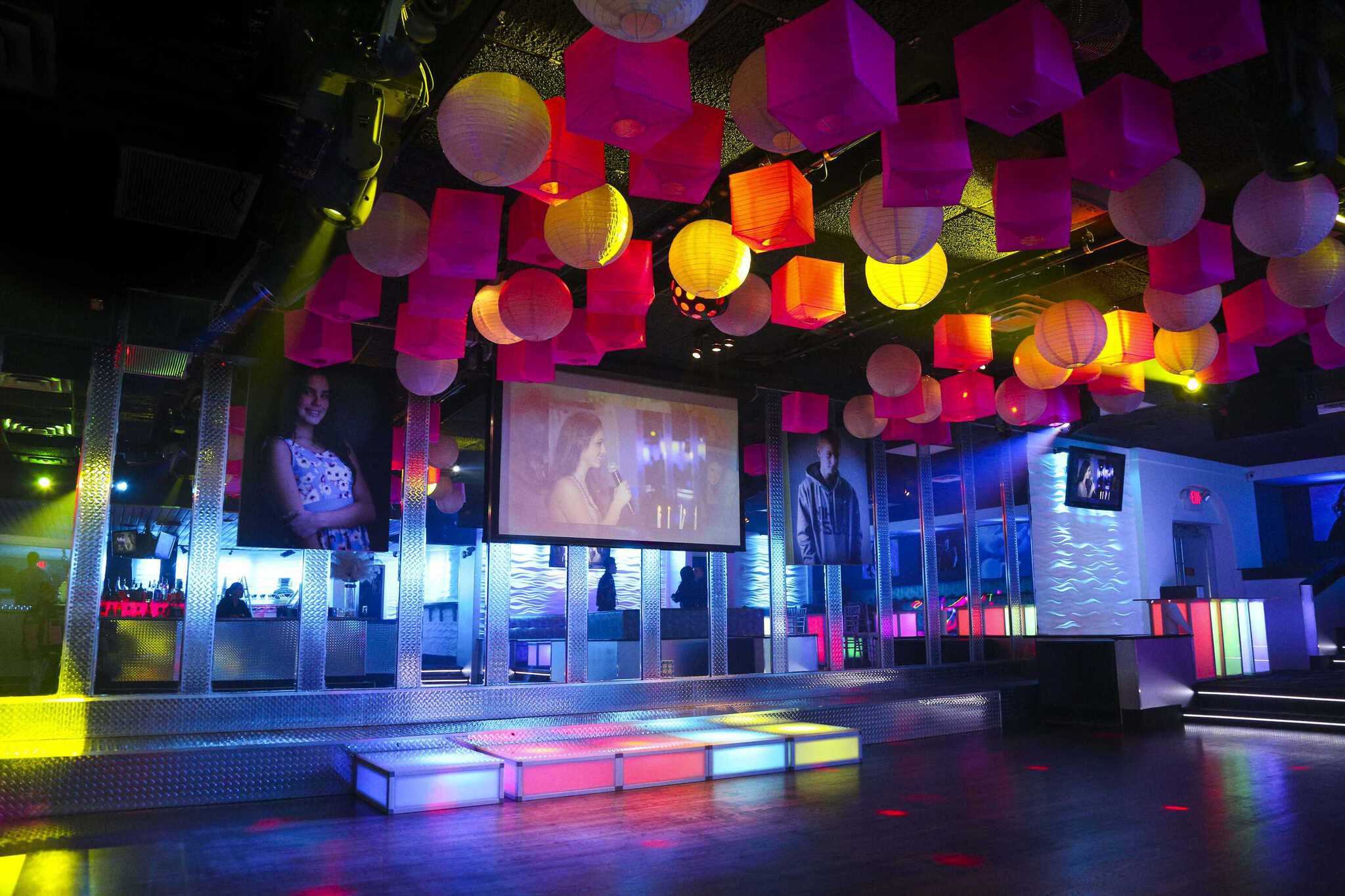 A Double G event space prepared with a glowing dance floor and colorful suspended décor